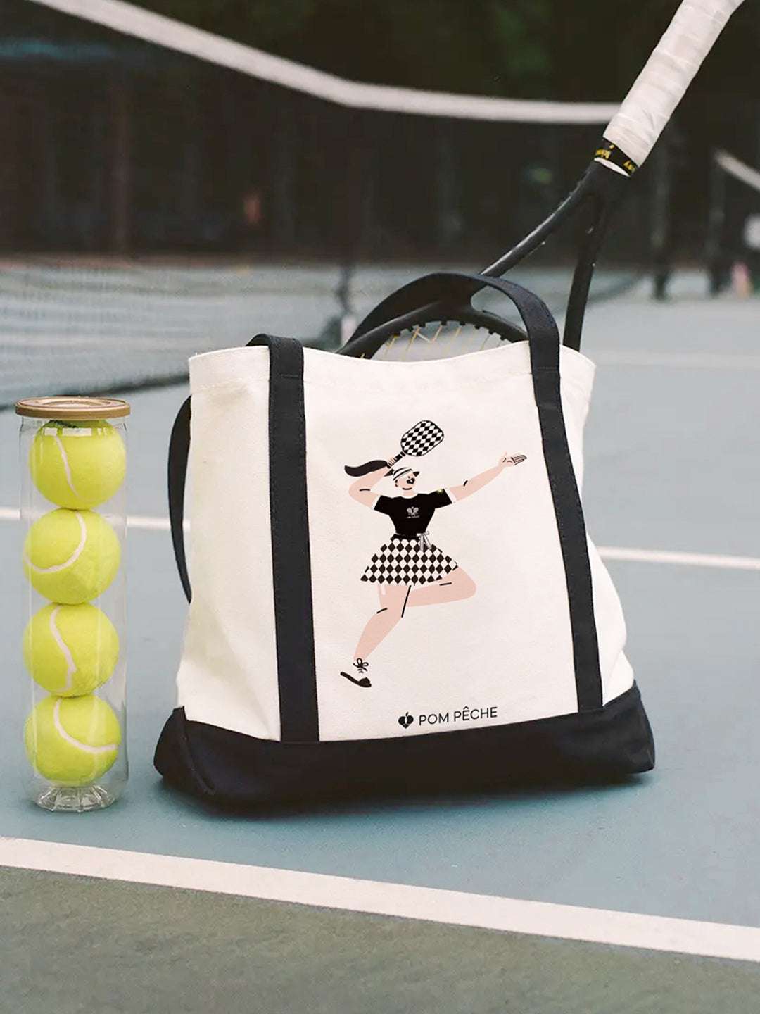 Canvas tote bag with black strap handles, featuring a printed Tennis Girl graphic.