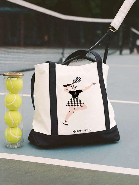 Canvas tote bag with black strap handles, featuring a printed Tennis Girl graphic.